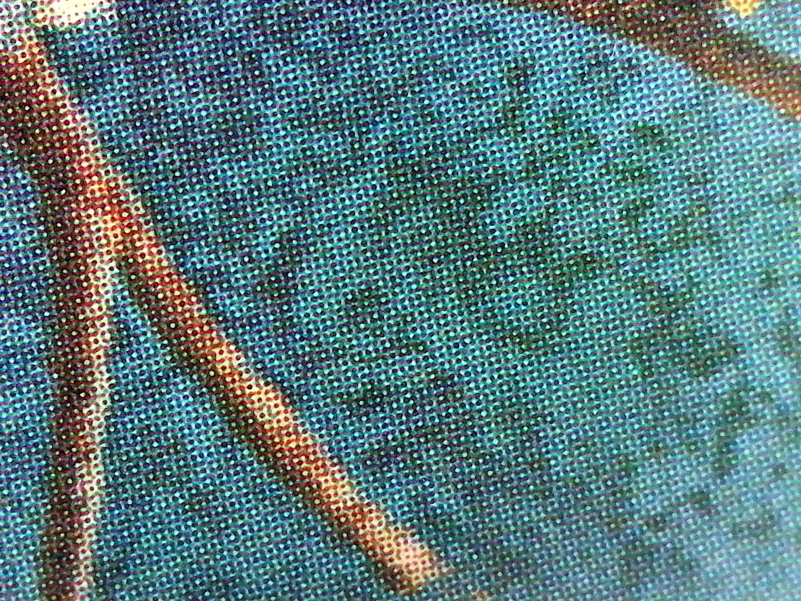 Points de trame cyan, magenta, jaune et noir d'une image imprimée en quadrichromie, vus à fort grossissement